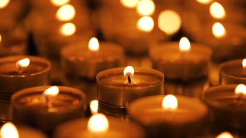 Illuminated Candles Burning in a Dark Setting