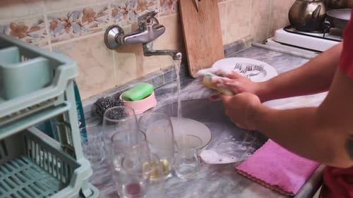 Washing Dishes in Kitchen Sink