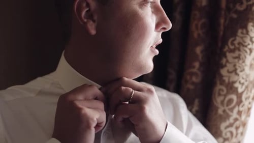 Man Smiles Buttoning Shirt Close Up