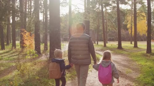 Father and Children Taking Stroll through Forest