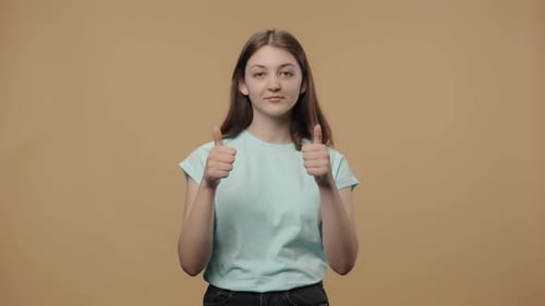Young Woman Gesturing Approval with Thumbs Up