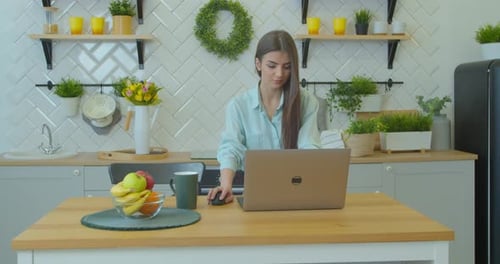 Woman Working on Laptop in Bright Kitchen