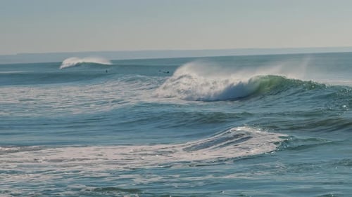 Big splashing ocean wave rushes towards the coast on a sunny day