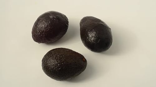 Close Up of Three Shiny Black Avocados