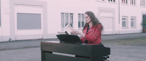Woman Plays Electric Piano Outside Industrial Building