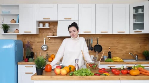 Woman Preparing Salad in Bright Kitchen