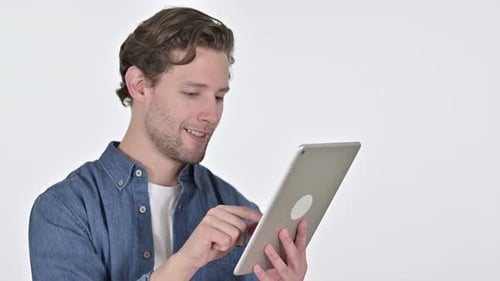 Joyeux jeune homme utilisant une tablette numérique sur fond blanc