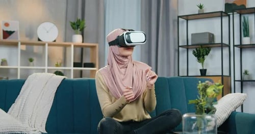 Woman Experiencing Virtual Reality with Headset on Couch