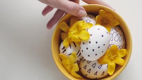 Decorated Easter Eggs in Yellow Bowl with Flowers