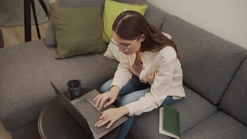 Young Woman Types on Laptop at Home
