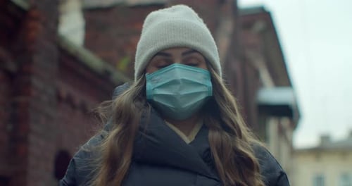 Close Up Portrait of a Beautiful Young Woman Wearing Protective Medical Face Mask and Standing on