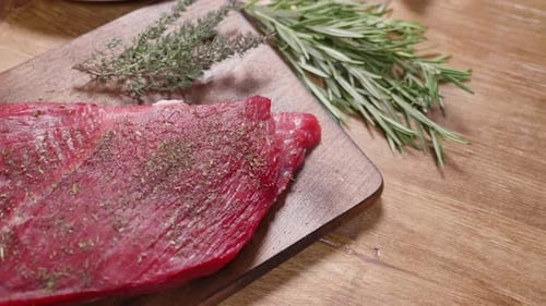 Slowly Revealing a Fresh Raw Chunk of Meat on an Aged Wooden Board