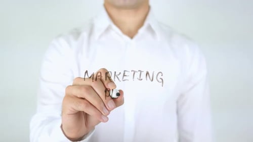 Man Writes Marketing Plan on Clear Surface