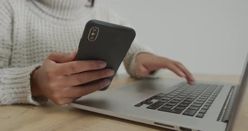Woman using laptop and smartphone
