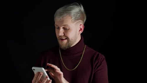 Lächelnder glücklicher stilvoller junger Mann mit Handy Look überrascht Wow Gefühl Glück Genuss