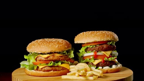Two Delicious Burgers with Fries on Turntable