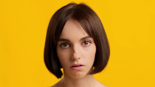 Woman Makes Faces Against Yellow Background