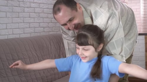 Loving Father Plays Airplane with Happy Daughter Indoors