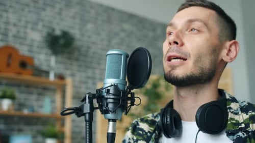 Close Up of Happy Bearded Guy Talking in Microphone Smiling Recording Podcast