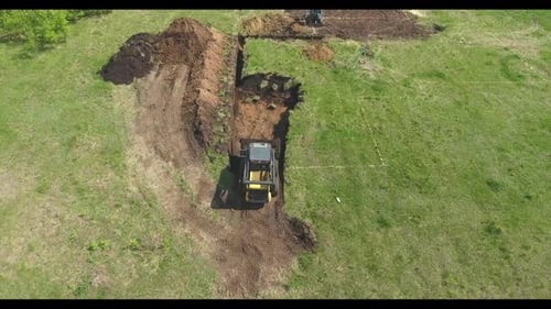 Excavator and Tractor Digging Trench on Construction Site