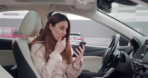 Woman Reacts to Phone in Car with Sadness