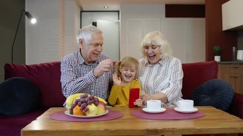 Girl showing grandparents how to use phone