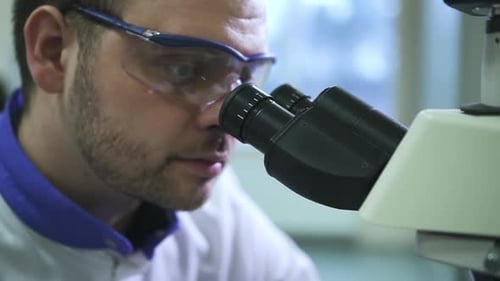 Close Up of Man Using Microscope in Lab