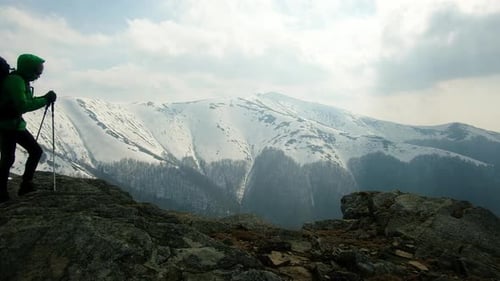 Hiker Ascending Snowy Mountain Ridge in Winter