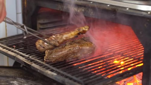 Chef Prepares Beef Steak Slow Motion Video: Flips Meat in Grill Charcoal Oven. Cooking Process on