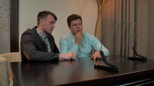 Men Discussing Technology in Modern Office