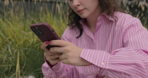 Close up shot. Beautiful woman with curly hair using smartphone technology app