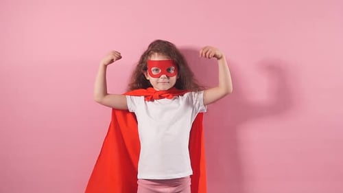 Young Girl Dressed as Superhero Flexing Arms