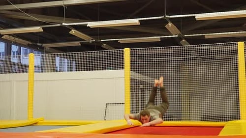 Young Man Doing Flips on Indoor Trampoline
