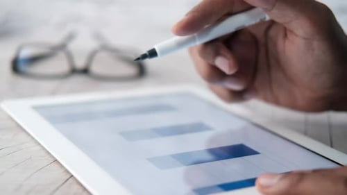 Man's Hand Working on Digital Tablet at Office Desk, Using Self Created Chart