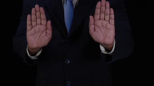 Man in Suit Holds Up Hands in Protest