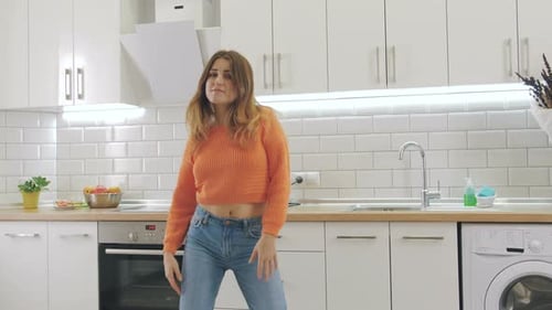 Woman Dancing Freely in Modern Kitchen