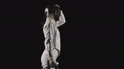 Side View Portrait of a Professional Woman Fencing Athlete Which Puts on a Protective Mask and