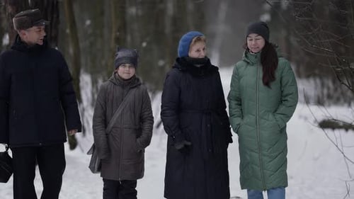 Family Is Walking at Winter Little Girl with Mother and Grandparents Is Strolling in Snowy Park or