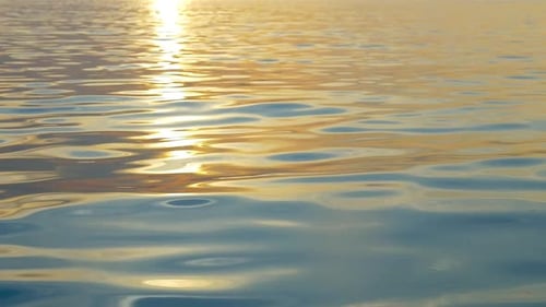 Plätscherndes Wasser mit Reflexion bei Sonnenuntergang