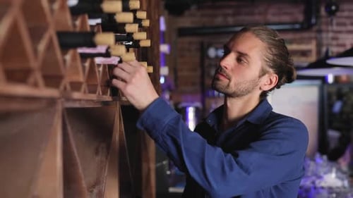 Wine Restaurant. Handsome Man Choosing Wine Bottle On Shelf