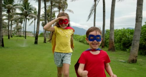 Happy Children Playing Superheroes on Tropical Lawn