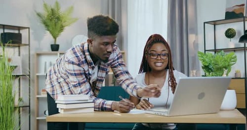 Pareja africana navegando por Internet con una computadora portátil en casa