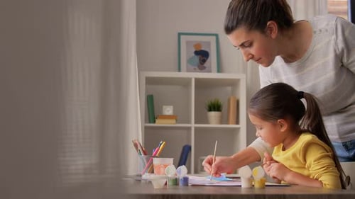 Woman and Child Enjoying Painting Together at Home