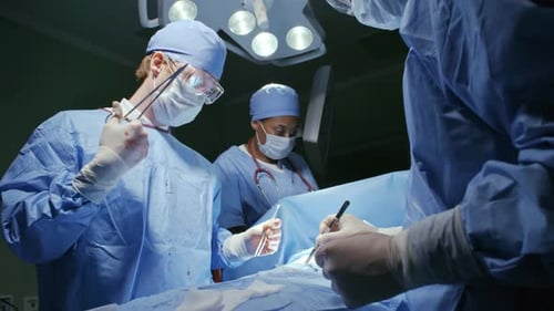 Team von Chirurgen, die Patienten zusammennähen