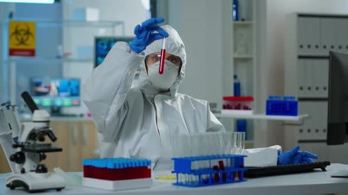 Scientist Inspecting Blood Sample in Lab Setting