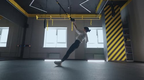 Sporty Woman Doing TRX Exercises in the Gym