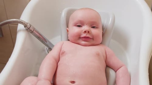 Happy Fair-Skinned Baby Getting a Bath