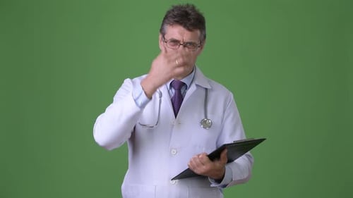 Mature Handsome Man Doctor Against Green Background