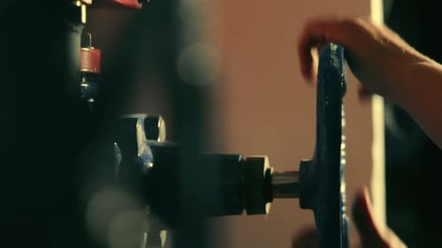 Adult Hands Turning a Large Blue Valve