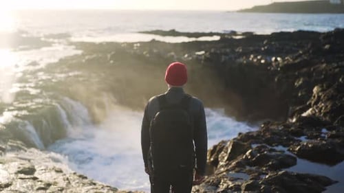 Man Watching Rock Pool Fill With Sea